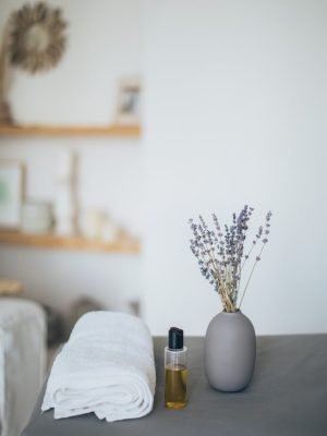 A Lavender Near the Bottle with Oil and a Bath Towel