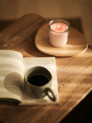 Cup of Coffee on a Book and a Candle