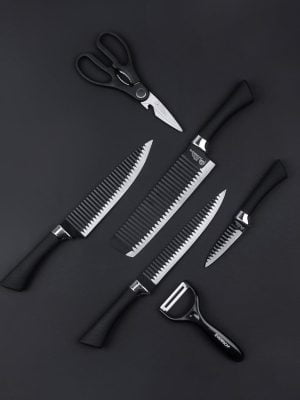 Top view of various kitchen utensils including knives scissors and vegetable peeler on black background